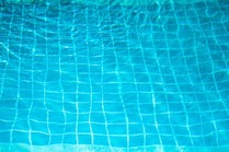Picture of clear water over the bottom of a pool, showing the tiles