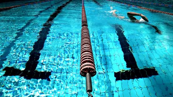 Picture of a swimming competitive pool, from the angle of the rope between the lanes